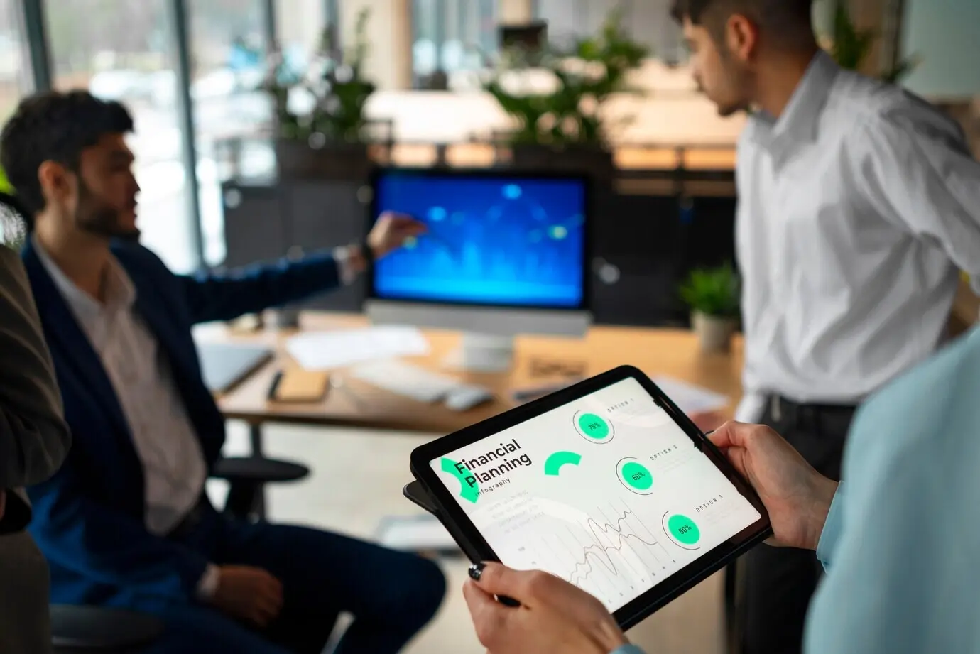 Люди в офисе анализируют и проверяют финансовые графики.