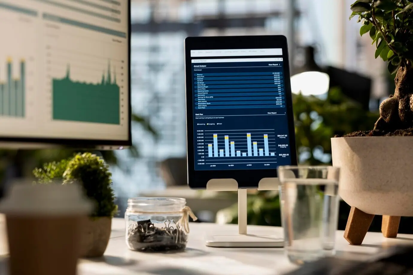 Пустое деловое рабочее пространство с устройством, на котором отображаются аналитика данных и инфографика.